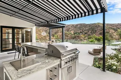an outdoor kitchen with a grill and a patio at Beverly Hills Maison in Beverly Hills