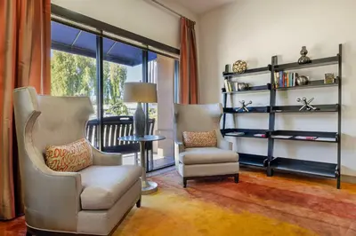 a living room with two chairs and a book shelf at Best Western Royal Palace Inn & Suites in Los Angeles