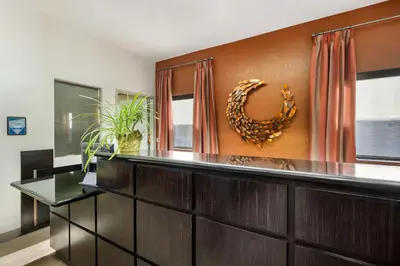 a living room with a wooden wall with a mirror at Best Western Royal Palace Inn & Suites in Los Angeles