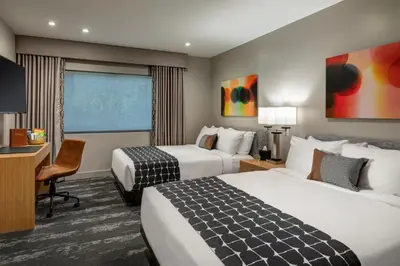 a hotel room with two beds and a desk at Olivia Hotel in Los Angeles