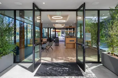 an office lobby with glass doors and a welcome mat at Olivia Hotel in Los Angeles