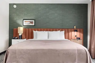 a bedroom with a large bed and a green wall at Royal Palace Westwood Hotel in Los Angeles