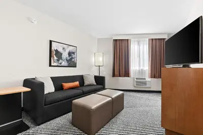 a living room with a couch and a flat screen tv at Royal Palace Westwood Hotel in Los Angeles