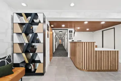 an office lobby with a hallway with a reception desk at Royal Palace Westwood Hotel in Los Angeles