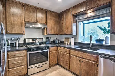 a kitchen with wooden cabinets and a stove top oven at Luxe Lake Arrowhead Getaway with Treetop Views! in Lake Arrowhead