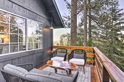a balcony with a table and chairs on a deck at Luxe Lake Arrowhead Getaway with Treetop Views! in Lake Arrowhead