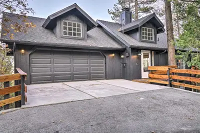 a house with a garage door and a driveway at Luxe Lake Arrowhead Getaway with Treetop Views! in Lake Arrowhead