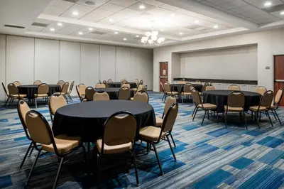 a conference room with tables and chairs and a whiteboard at Holiday Inn Express Ontario by IHG in Creekside