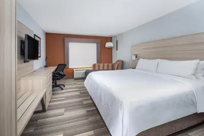 a hotel room with a bed and a desk and a television at Holiday Inn Express Ontario by IHG in Creekside