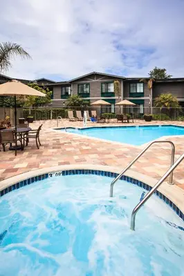 a pool with tables and umbrellas at a hotel at Holiday Inn Express & Suites Carpinteria by IHG in Carpinteria