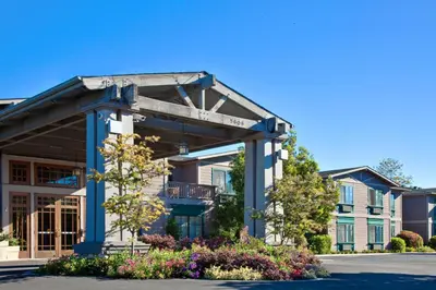 a building with a porch and flowers in front of it at Holiday Inn Express & Suites Carpinteria by IHG in Carpinteria