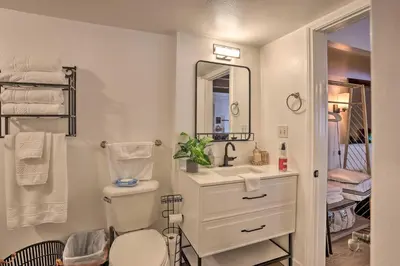 a bathroom with a sink and a toilet and a mirror at Modern Cabin with Game Room and Deck, Near Skiing in Running Springs