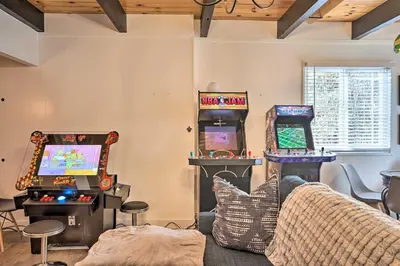 a living room with two arcade games and a couch at Modern Cabin with Game Room and Deck, Near Skiing in Running Springs