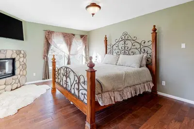 a bedroom with a large bed and a fireplace at Running Springs R-n-R in Running Springs