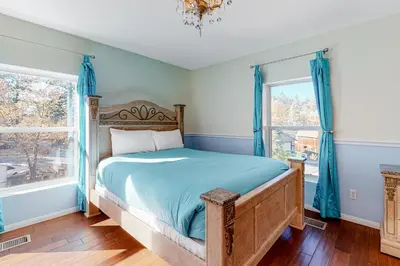 a bedroom with a bed and two windows at Running Springs R-n-R in Running Springs