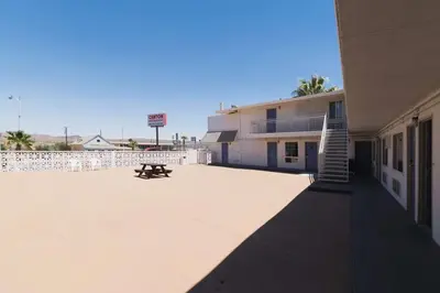 a building with a bench in the middle of a courtyard at Motel 6-Barstow, CA - Route 66 in Barstow