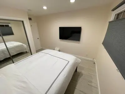 a bedroom with a bed and a flat screen tv at Cheerful, Beautifully Remodeled, Modern, Comfortable Home in Los Angeles