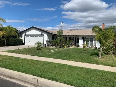 a white house with a palm tree in front of it at Cheerful, Beautifully Remodeled, Modern, Comfortable Home in Los Angeles