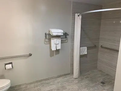 a bathroom with a shower and a toilet and towels at Buena Park Inn in Anaheim