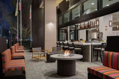 a restaurant with a table and chairs and a bar at Home2 Suites By Hilton Woodland Hills Los Angeles in Woodland Hills