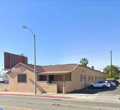 a building with a car parked in a parking lot at EL PATIO HOTEL in San Bernardino