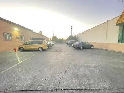 a parking lot with cars parked next to a building at EL PATIO HOTEL in San Bernardino