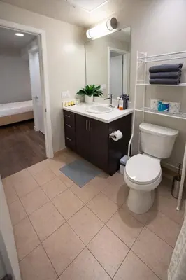 a bathroom with a toilet and a sink and a mirror at ViewPoint Suites in Los Angeles