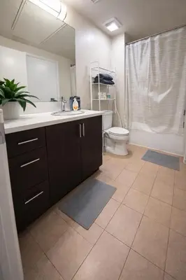 a bathroom with a sink and a toilet and a mirror at ViewPoint Suites in Los Angeles