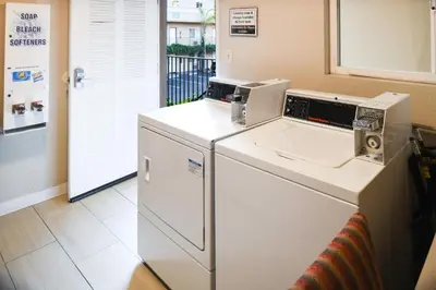 a laundry room with a washer and dryer at Anaheim Islander Inn and suites near Park and Convention center in Anaheim