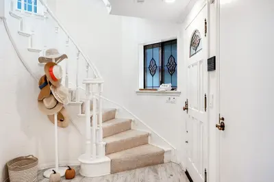 a white staircase in a home with white walls at Sandcastle by the Sea in Oxnard