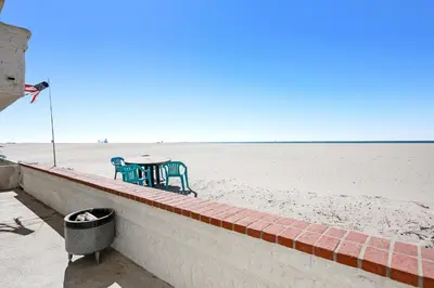 a table and chairs sitting on the beach at Sandcastle by the Sea in Oxnard