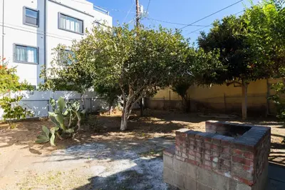 a yard with a brick wall and trees and a building at Los Angeles 3 Bedroom Charmer Large Guest House in Los Angeles
