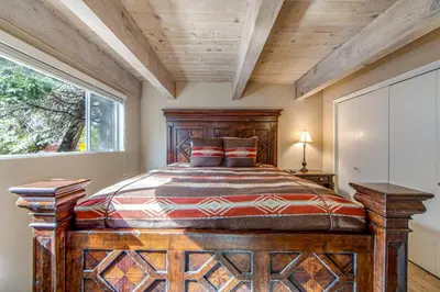 a bedroom with a large wooden bed and a window at Adorable Explorable in Lake Arrowhead