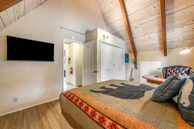 a bedroom with a bed and a flat screen tv at Adorable Explorable in Lake Arrowhead