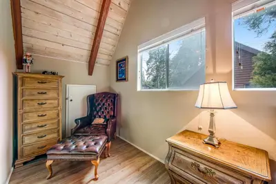 a room with a chair and a lamp on a dresser at Adorable Explorable in Lake Arrowhead