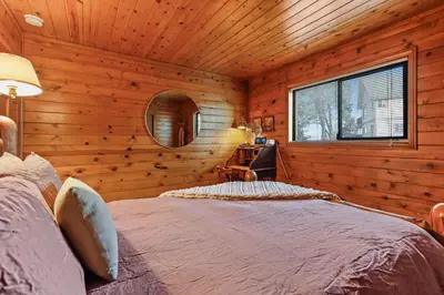 a bedroom with a bed in a log cabin at Howard's Cabin in Lake Arrowhead