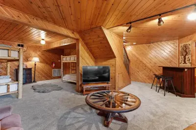 a living room with a flat screen tv in a log cabin at Howard's Cabin in Lake Arrowhead
