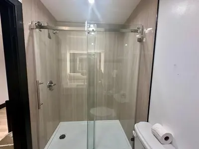 a glass shower in a bathroom with a toilet at Casa Playa Inn - Stanton, Anaheim in Stanton