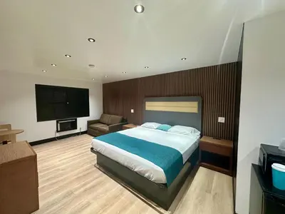 a bedroom with a bed and a flat screen tv at Casa Playa Inn - Stanton, Anaheim in Stanton