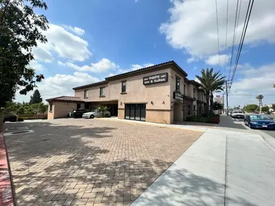 an empty parking lot in front of a building at ASPIRE INN & SUITES Orange in Orange