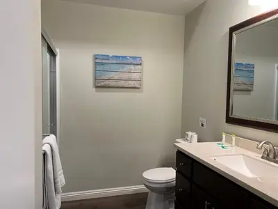 a bathroom with a sink and a toilet and a mirror at ASPIRE INN & SUITES Orange in Orange