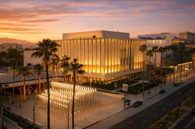 a building with palm trees in front of a street at Modern LA Home Near Museums, Dining & Downtown in Los Angeles