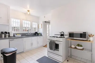 a white kitchen with a stove and a microwave at Modern LA Home Near Museums, Dining & Downtown in Los Angeles