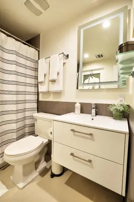 a bathroom with a toilet and a sink and a mirror at Classic Los Angeles Elegance in Downtown, Sleeps 4, Free Parking and 360 Degree View Roof Top Pool! in Los Angeles