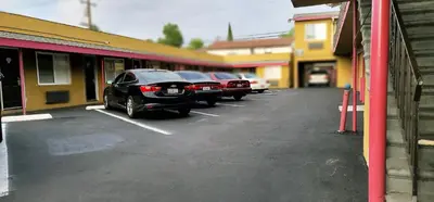 a row of cars parked in a parking lot at RUBY MOTEL in Long Beach