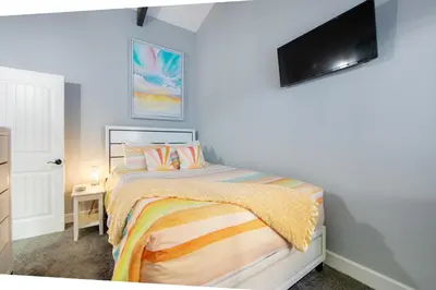 a bedroom with a bed and a tv on the wall at Arrowhead Aerie in Lake Arrowhead
