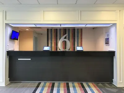 a reception desk in an office with a sign on it at Studio 6 Artesia CA in Artesia