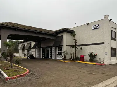 a building with a parking lot in front of it at Studio 6 Artesia CA in Artesia
