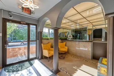 an open lobby with yellow chairs and a bar at La Mirage Inn - Hollywood in Los Angeles