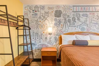 a bedroom with a bed and a wall with drawings on it at La Mirage Inn - Hollywood in Los Angeles